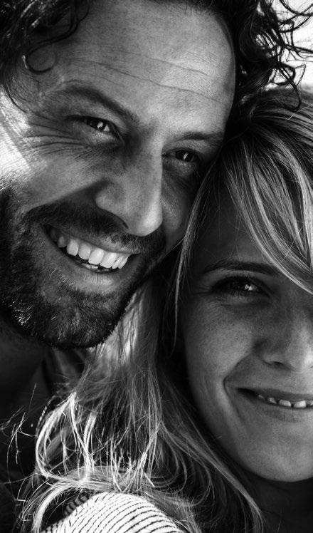 Una pareja adulta comparte un momento de cercanía y sonrisas al aire libre.